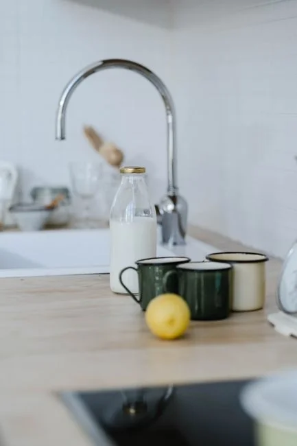 A clean and organized home office desk with a cleaner bottle and sponge, emphasizing simplicity and functionality.